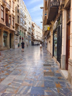 Cartagena, İspanya-13 Haziran 2022 - İspanya 'nın güneyindeki Kartagena sokakları güneşli bir günde. Kıyı şehrinde gezinen insanları ve tipik mimariyi görebilirsiniz..