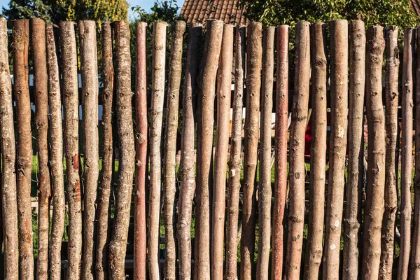 stock image a fence constructed with rough stems and thick branches of trees at a residential building