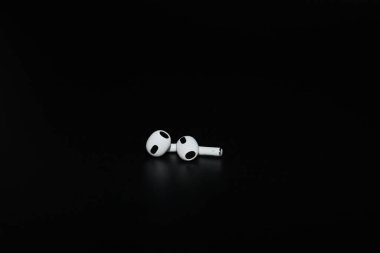 Kyiv, Ukrayna - 14 Ekim 2022: Apple AirPods (3. nesil). Gerçek kablosuz kulaklıklar, Apple kulaklıkları. Siyah arkaplanda Uzamsal Ses olan Beyaz Elma Hava Modülleri 3