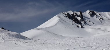 Mavi gökyüzü ve karla kaplı dağ zirveleri..