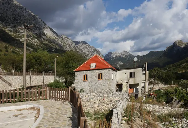 Dağ zirveleri ve tipik bir taş ev..