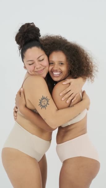 身着内裤 面带微笑 拥抱对方的快乐的多种族胖女人的静态镜头 同时在灰色背景下表现出身体的积极态度 — 图库视频影像