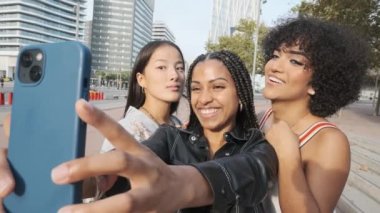 Bir transseksüel kadın ve iki çok ırklı arkadaşın sokakta selfie çekerken yavaş çekim videosu.