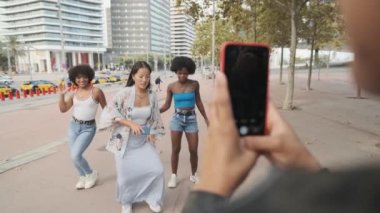 Tanımlanamayan bir kadının, arkadaşlarının sokakta dans edişinin videosunu yavaş çekim videosu.