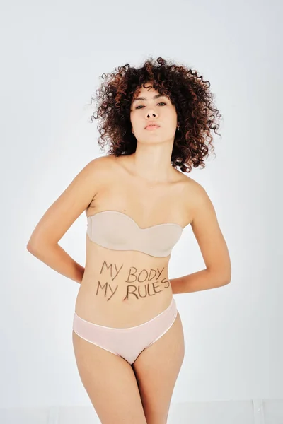 私の体でカメラを見て自信を持って裸の巻き毛民族の女性モデル私のルールは 胃の上に書かれました — ストック写真