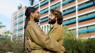 Çok ırklı eşcinsel bir çifti gezdirip şehirde kucaklaşan yavaş çekim videosu.