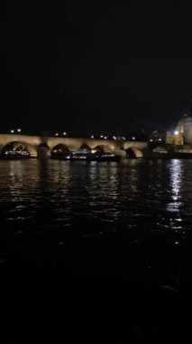 Prag 'da geceleri aydınlanan bir ortaçağ köprüsünün yan yana seyahat videosu