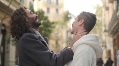 Şehirde şefkatle kucaklaşan mutlu bir homoseksüel çiftin yavaş çekim videosu.