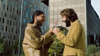 Eşine sürpriz bir hediye olarak çiçek veren siyahi bir adamın yavaş çekim videosu ve sonra sokakta sarılma.