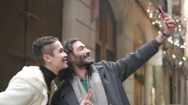 Şehir sokaklarında selfie çeken eşcinsel bir çiftin yavaş çekim videosu.