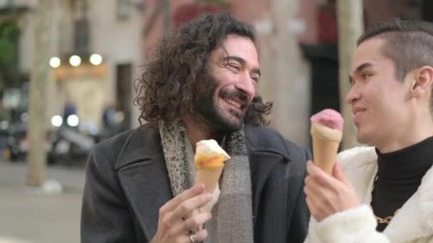 スローモーションビデオとともに旅行の周りにA幸せなゲイカップルイチャイチャしばらく食べますAアイスクリームでザ通り — ストック動画