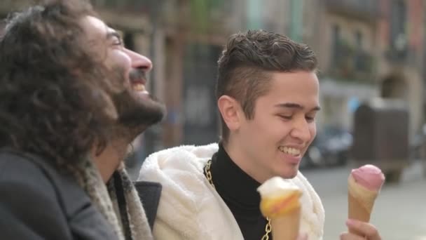 スローモーションビデオありますに焦点を当てていますゲイのカップルと路上でアイスクリームを食べる同性愛者 — ストック動画