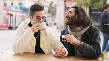 Kafeteryada kahve içerken şakalaşan ve gülen mutlu bir çiftin yavaş çekim videosu.