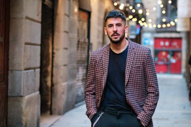 Sokakta poz verirken kameraya bakan şık bir adamın portresi.