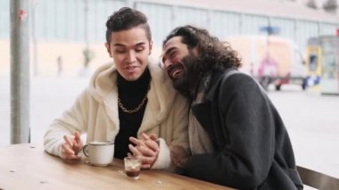 Şehirdeki açık bir kafeteryada gay aşıkların kahve içişini gösteren yavaş çekim videosu.