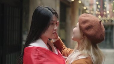 Sokakta lgbt bayrağıyla sarılan Asyalı lezbiyen bir çiftin romantik bir sahnesinin yavaş çekim videosu.