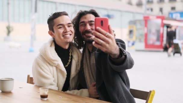 ゆっくりムービービデオのAクールで幸せなゲイカップル取りますA自画撮りながらキスで屋外カフェテリア — ストック動画