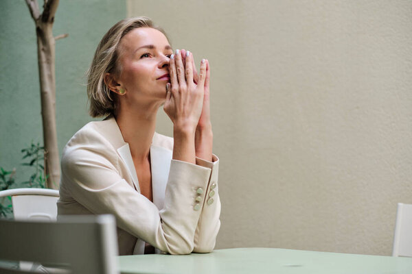 Worried woman thinking about something while sitting outdoors.