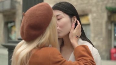 Slow motion video with travelling arround a lesbian asian couple kissing in the street