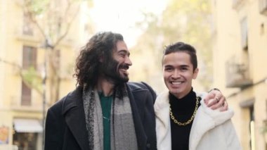 Slow motion video of a cool gay couple walking with shopping bags along the city street