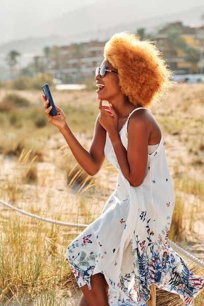 Foto Vertical Una Mujer Afro Riendo Mientras Habla Una Selfie —  Fotos de Stock