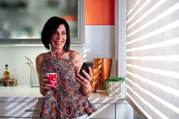 Dospělá Běloška Pije Kávu Během Videohovoru Mobilem Doma — Stock fotografie