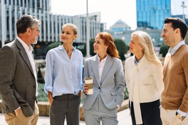 Bir grup iş adamının portresi. Şehir caddesinde durmuş kahve içiyorlar.