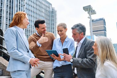 Şehirdeki bir toplantıda bir grup iş adamı tablet kullanıyor.