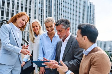 Bir iş toplantısında açıklama yapılırken tablet kullanan insanlar