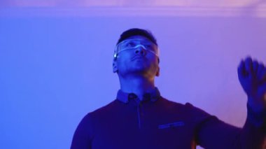 Mutlu Çinli bir adamın arttırılmış gerçeklik gözlüğü kullanırken el kol hareketi videosu.