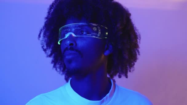 一个非洲男人在蓝色房间里戴着增强型现实镜的慢镜头 — 图库视频影像