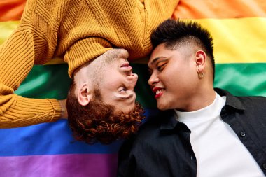 Igtb gökkuşağı bayrağında uzanan hassas bir eşcinsel çiftin üst görüntüsü