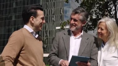 Bir projede dizüstü bilgisayarla çalışan üç iş adamının yavaş çekim videosu.