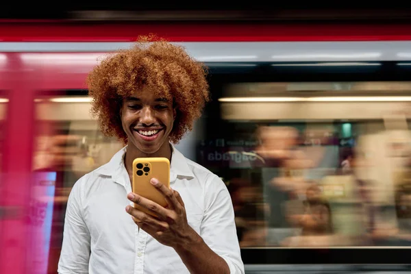 Hombre Pelo Afro Joven Usando Teléfono Inteligente Mientras Viaja —  Fotos de Stock