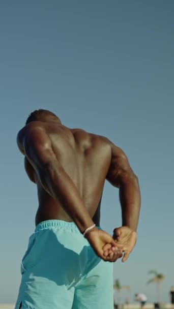 一个活跃的黑人男子在室外热身和伸展的后视镜的垂直慢镜头 — 图库视频影像