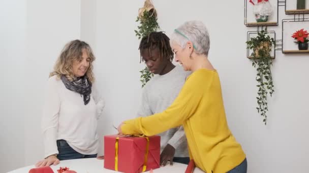 Pareja Lesbiana Mediana Edad Disfrutando Envolver Regalo Navidad Con Hijo — Vídeos de Stock