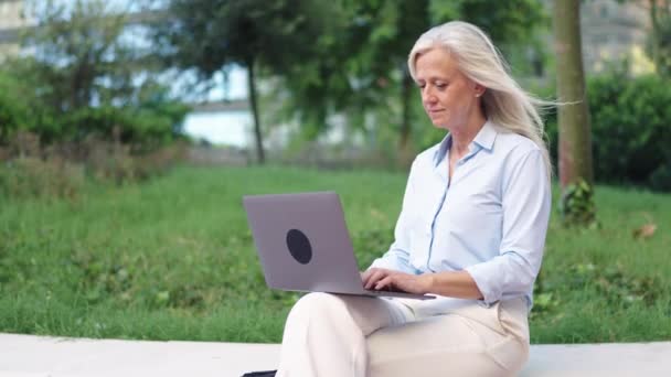 Senior Businesswoman Using Laptop Vibrant Green Modern District Sustainable Workspace — Stock Video