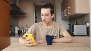 Akıllı telefon içeriğini izleyen hoşnutsuz genç bir gay.