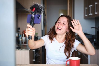 Genç kız cep telefonuyla evden video kaydederken sallanıyor.