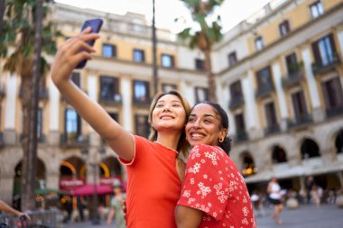 Barselona 'da bir meydanda cep telefonuyla selfie çeken lezbiyen çift.