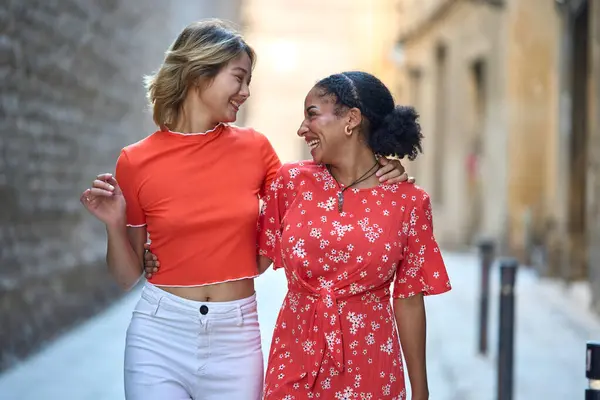 Queer couple embracing and walking in a narrow street of Barcelona