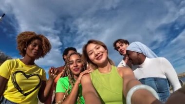 Bin yıllık Çinli kız ve çok ırklı arkadaşları dışarıda selfie çekiyorlar.