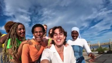 Bir grup çok ırklı ve çok ırklı arkadaşı olan genç adam dışarıda selfie çekiyor.