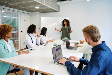 Meslektaşlarına projeyi açıklayan bir kadınla bir odanın içinde buluşmak.