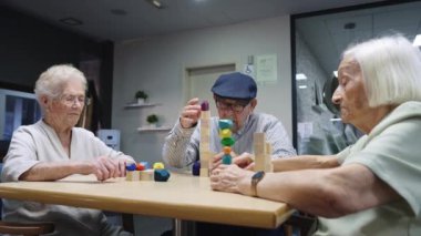 Yaşlı insanların yaşlılarla oyun oynamalarına yaklaşan bir hemşirenin videosu.