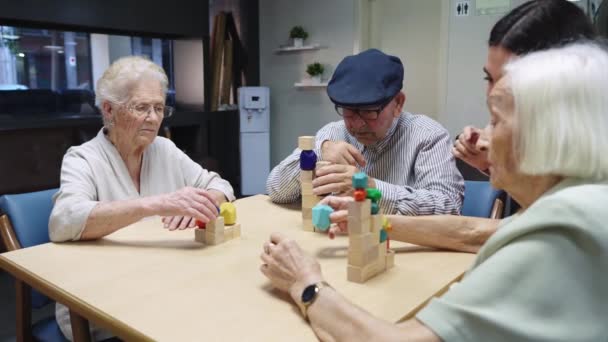 看護師や高齢者が看護施設で一緒にパズルスキルゲームを解決する様子 — ストック動画