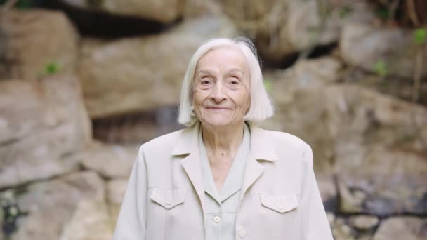 Video Van Een Oude Vrouw Glimlachend Naar Camera Buiten Een — Stockvideo