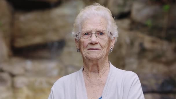 Huzurevinin Bahçesindeki Kameraya Gülümseyen Sallayan Yaşlı Bir Kadının Videosu — Stok video
