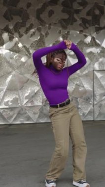 Vitiligo dansı yapan enerjik bir Afrikalı kadının dikey yavaş çekim videosu.