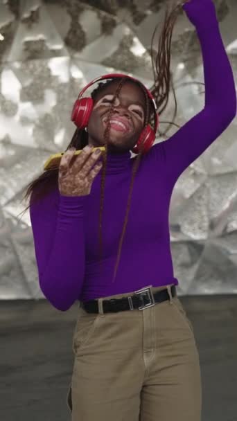 在城市里 一个有着白垩风的非洲女人用电话唱歌和听音乐的垂直慢动作视频 — 图库视频影像